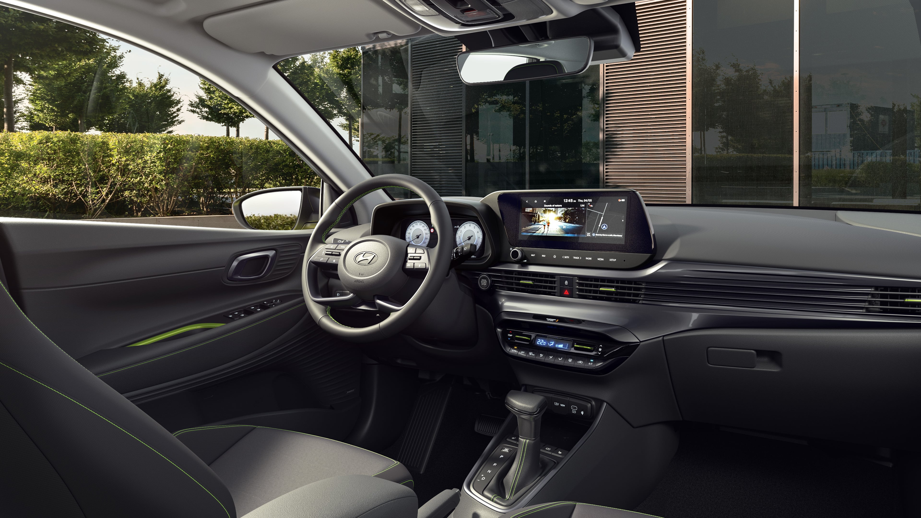 A backseat perspective of the driving wheel and dashboard of the Hyundai i20.